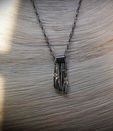 Pendentif brut en argent et or.