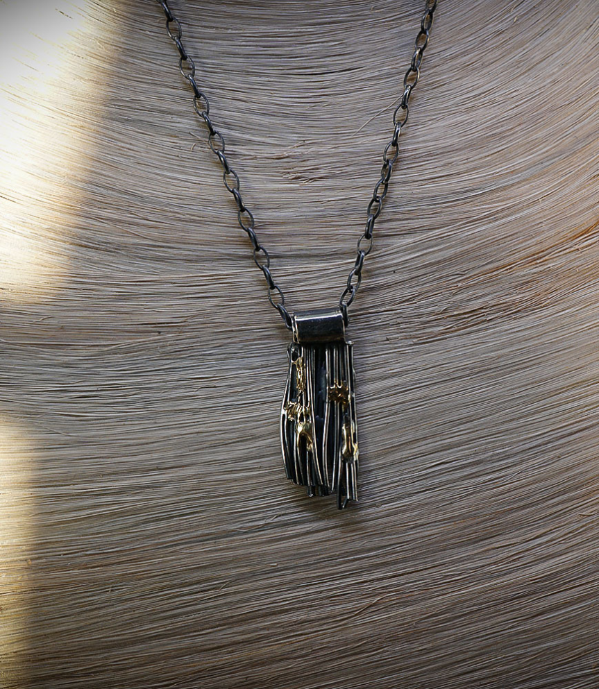 Pendentif brut en argent et or.