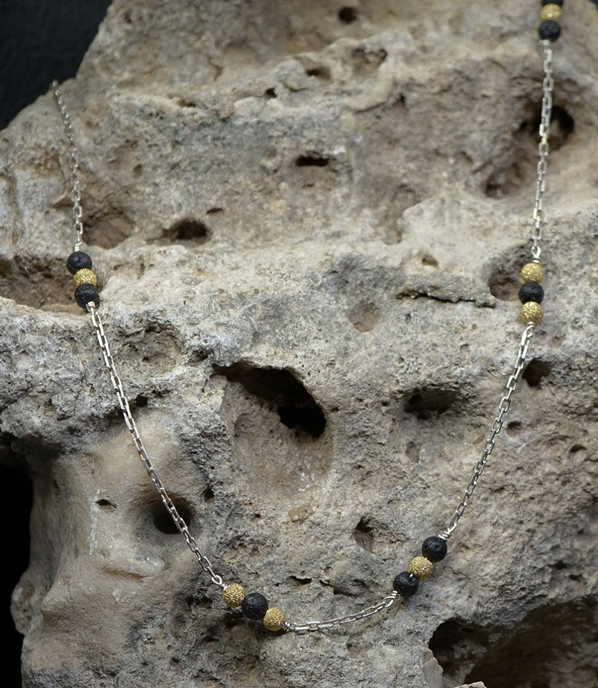 Ce collier marie la pureté de l'argent à des perles de véritable lave de Santorin