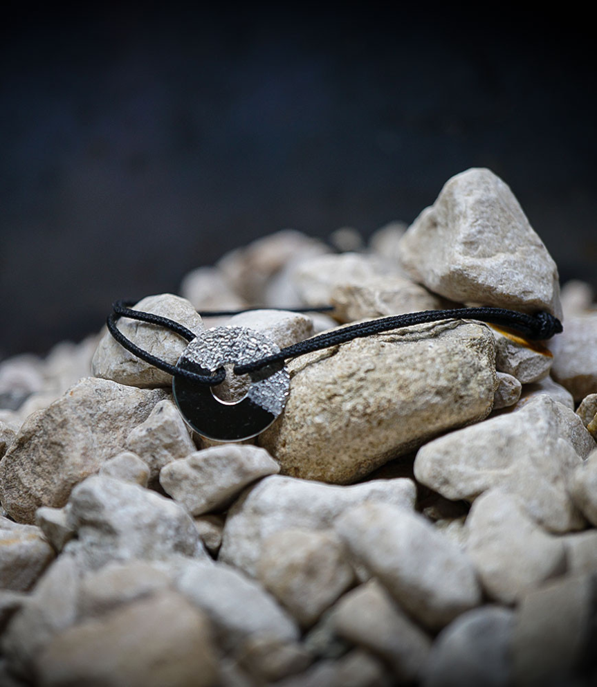 Adjustable cord bracelet in silver.